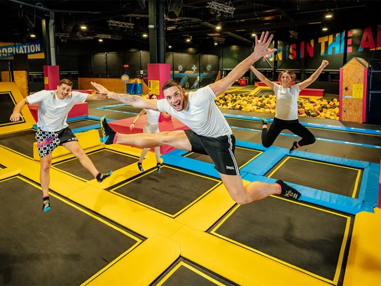 Springende Menschen auf Trampolinen in einem Indoor-Freizeitpark, voller Energie und Spaß. Ideal für aktive Freizeitgestaltung.