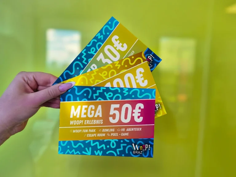 Händehaltung von drei Gutscheinen im Wert von 30€, 100€ und einem Mega-Gutschein über 50€ vor einer hellgrünen Wand.