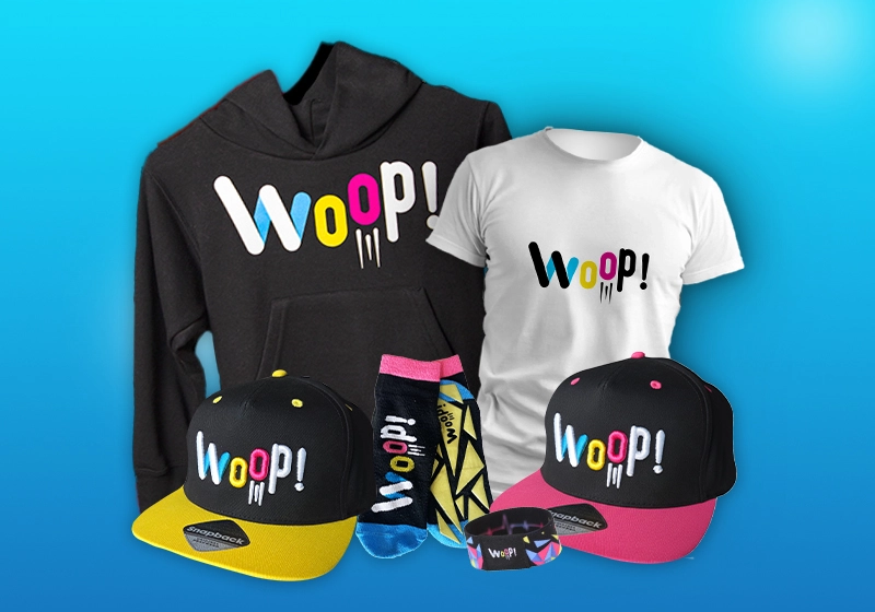 Buntes Woop! Merchandise-Set mit Hoodie, T-Shirt, Caps, Socken und Armband auf blauem Hintergrund.