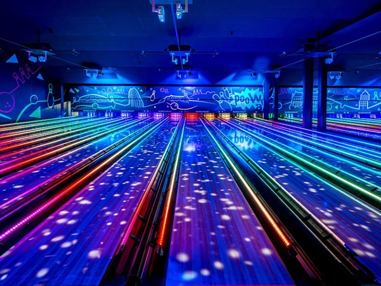 Bunte Bowlingbahn mit neonfarbenen Lichtern und modernem Design. Ideal für Freizeitaktivitäten und Partys.