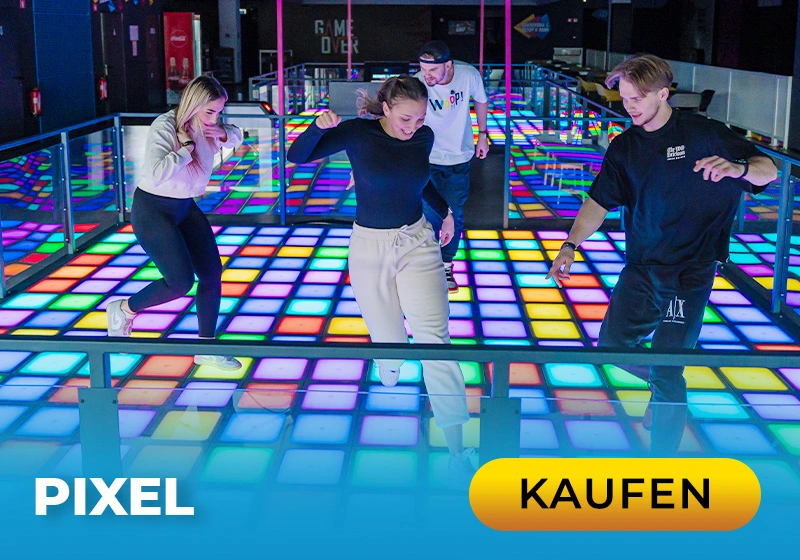 Vier Personen tanzen auf einem bunten, beleuchteten Boden in einer modernen Freizeitstätte. Spaß und Bewegung stehen im Vordergrund.