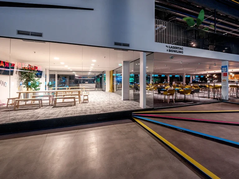 Moderne Freizeiteinrichtung mit Lasertag und Bowling, hell erleuchtet mit gemütlichen Sitzbereichen.
