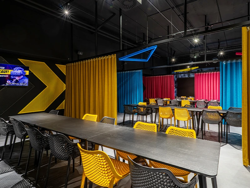 Moderne Besprechungsräume mit bunten Vorhängen und stylischen Stühlen, ideal für kreative Meetings und Veranstaltungen.