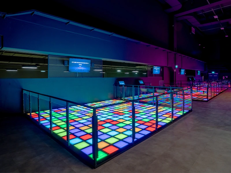 Bunte Tanzfläche mit leuchtenden Kacheln in einem modernen Veranstaltungsraum. Ideal für Partys und Events.