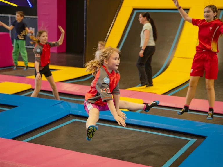 Kinder springen auf Trampolinen in einem Indoor-Spielplatz, Spaß und Bewegung für alle Altersgruppen.